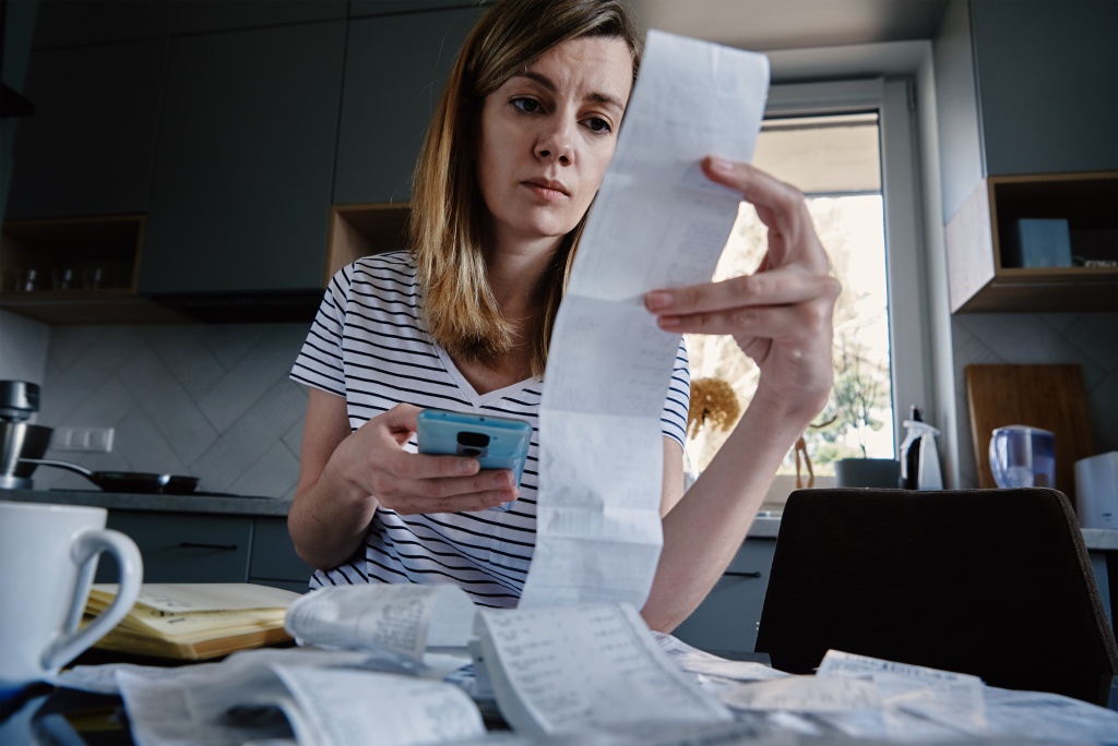 woman-looking-paper-bill-counting-expenses.jpg девушка